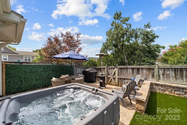 view of patio featuring fence and a hot tub