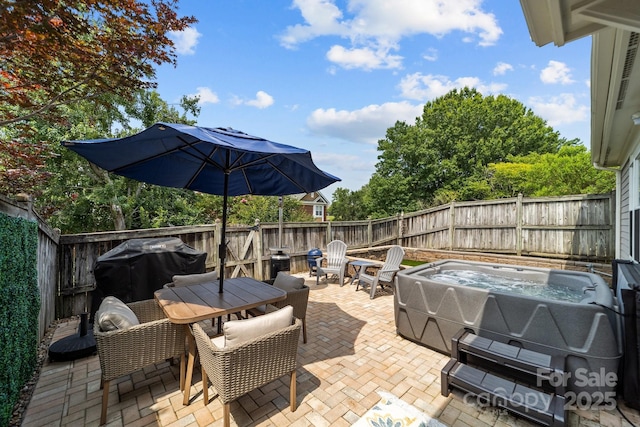 view of patio / terrace with outdoor dining area, a fenced backyard, and a hot tub