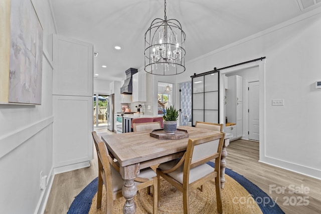 dining room with light wood finished floors, a barn door, baseboards, and recessed lighting