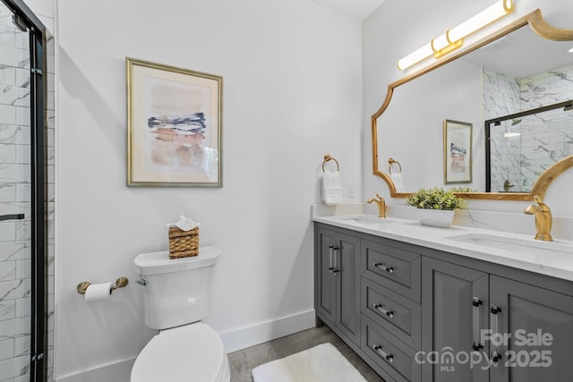 full bathroom featuring double vanity, a stall shower, a sink, and toilet