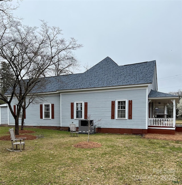 rear view of house featuring a shingled roof, crawl space, a yard, and a porch