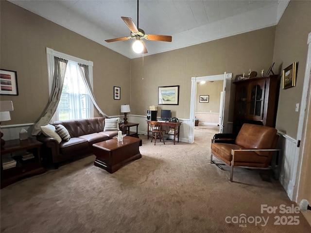 carpeted living area with vaulted ceiling and a ceiling fan