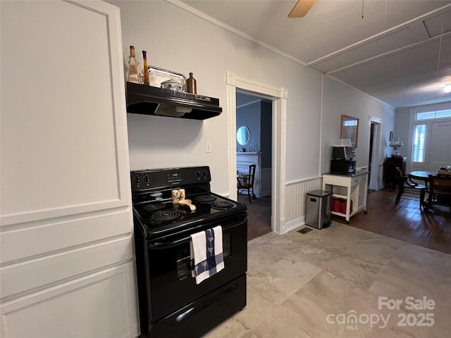 kitchen featuring crown molding, electric range, wainscoting, and under cabinet range hood