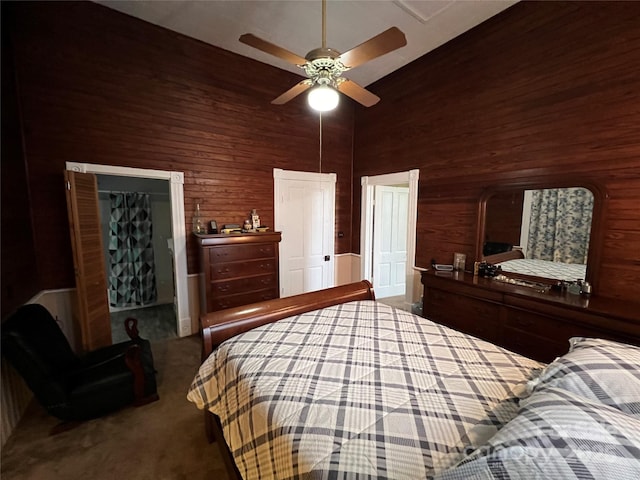 bedroom featuring high vaulted ceiling, carpet, ceiling fan, and wooden walls