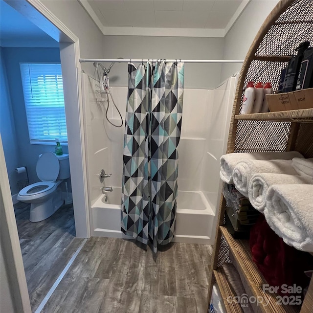 bathroom featuring toilet, crown molding, shower / tub combo with curtain, and wood finished floors