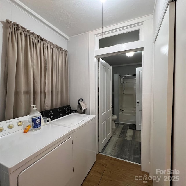 laundry area featuring laundry area, a textured ceiling, dark wood-type flooring, and washing machine and clothes dryer