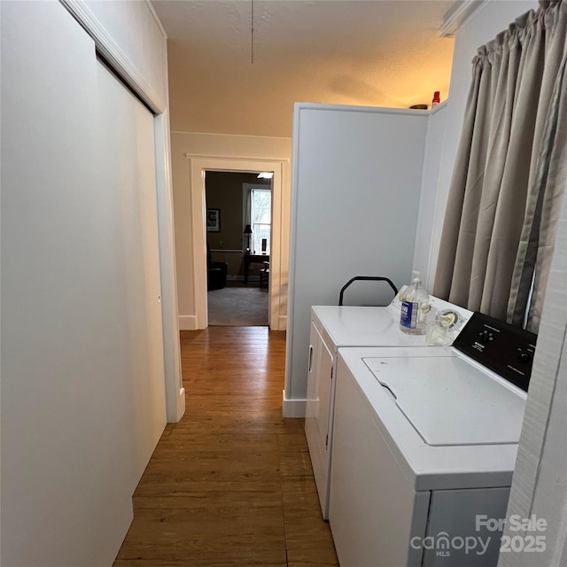 washroom with laundry area, wood finished floors, and independent washer and dryer