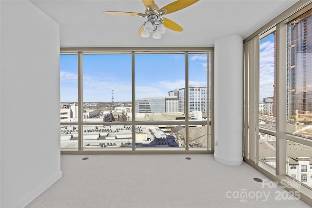 unfurnished sunroom featuring a view of city and ceiling fan