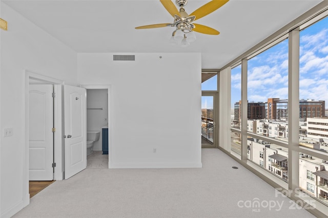 sunroom / solarium with a ceiling fan, a view of city, and visible vents