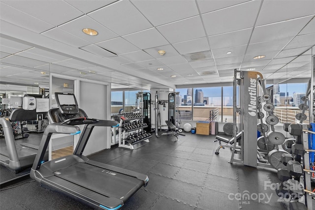 workout area with a view of city and a drop ceiling