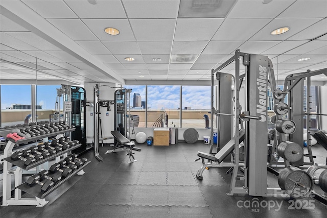 gym featuring a paneled ceiling and a view of city