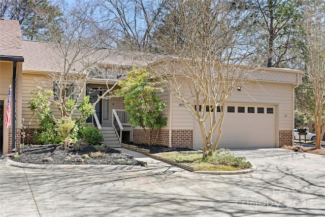 ranch-style home featuring a garage, concrete driveway, brick siding, and a shingled roof