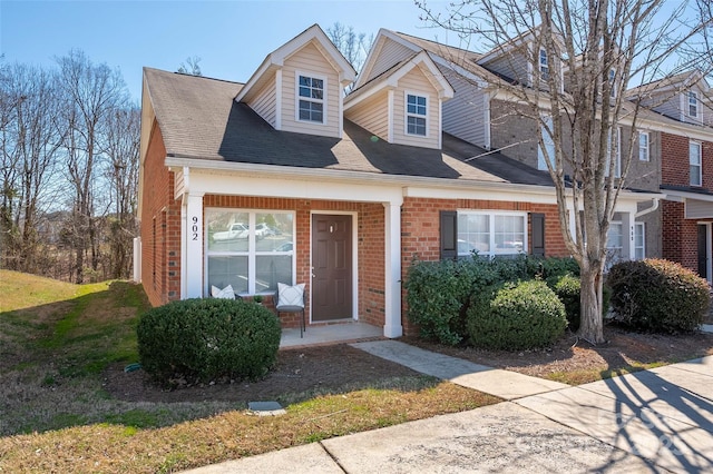 view of front of house featuring brick siding and a porch