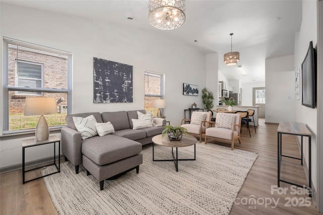 living room with high vaulted ceiling, wood finished floors, and visible vents