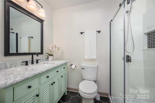 bathroom with toilet, vanity, baseboards, a shower stall, and tile patterned floors