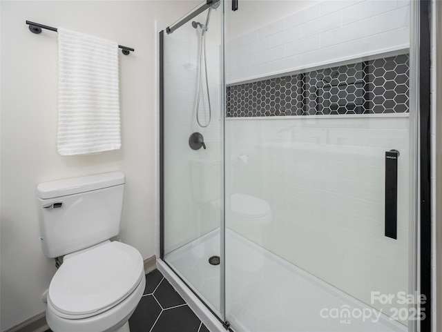 full bathroom featuring tile patterned flooring, a shower stall, and toilet