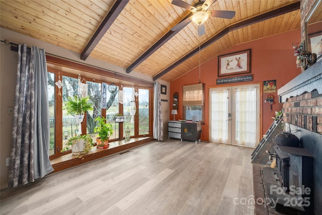 unfurnished living room with a ceiling fan, lofted ceiling with beams, wood ceiling, wood finished floors, and french doors