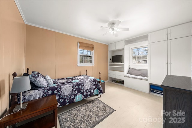 bedroom featuring ceiling fan, ornamental molding, and light wood-type flooring