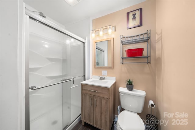 full bathroom with toilet, a stall shower, and vanity