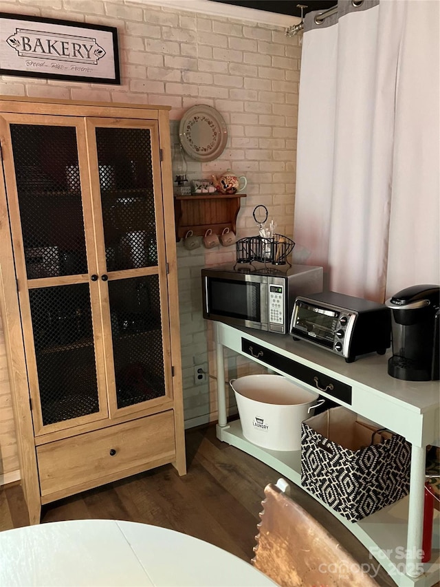 interior space with stainless steel microwave, wood finished floors, and a toaster