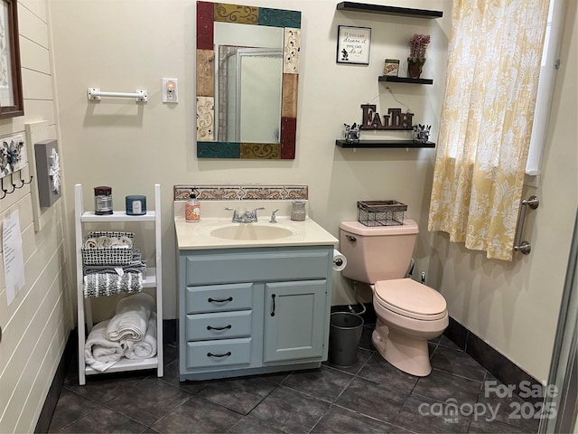 bathroom with toilet, baseboards, vanity, and tile patterned floors