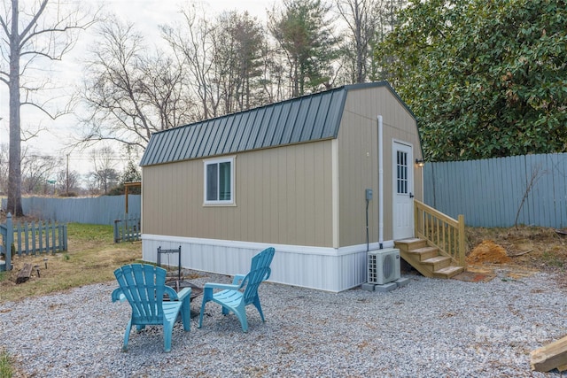 view of outbuilding featuring entry steps, ac unit, an outdoor structure, and a fenced backyard