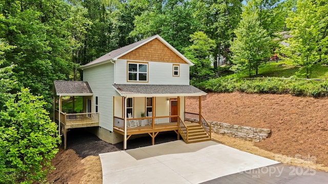 view of front of property with driveway, a porch, and roof with shingles