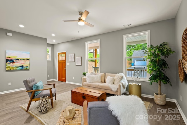 living room featuring recessed lighting, baseboards, visible vents, and light wood finished floors