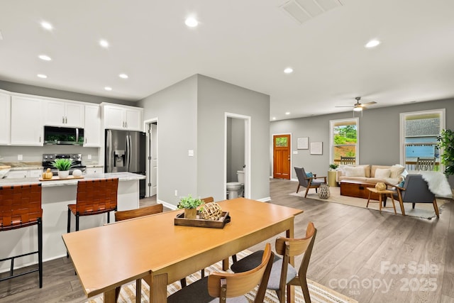 dining space featuring light wood finished floors, visible vents, and recessed lighting