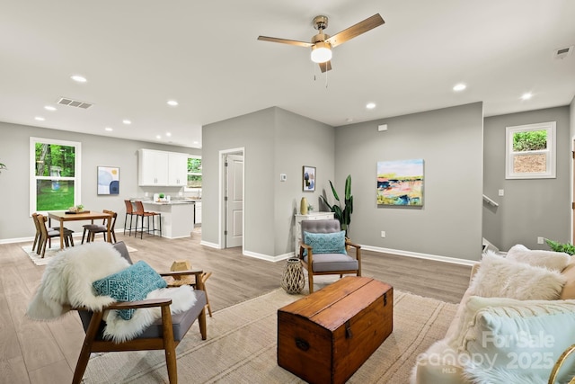 living room with light wood-type flooring, a wealth of natural light, and recessed lighting