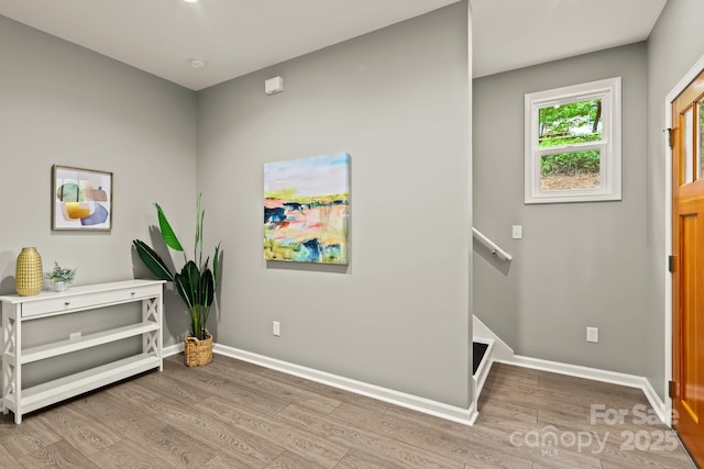 interior space featuring baseboards, wood finished floors, and an upstairs landing