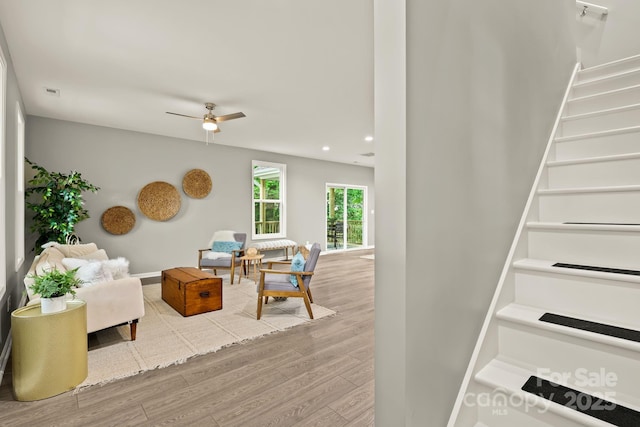 living room featuring ceiling fan, recessed lighting, wood finished floors, baseboards, and stairs