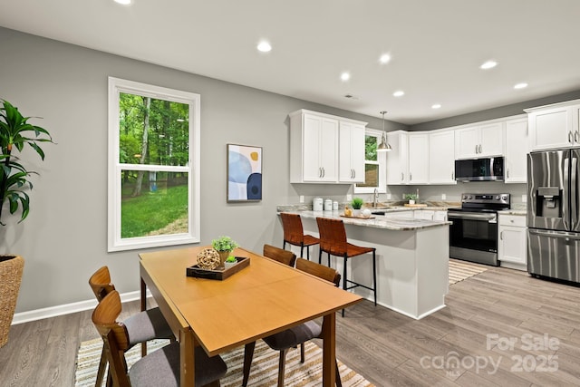 kitchen featuring a peninsula, a healthy amount of sunlight, appliances with stainless steel finishes, and a sink