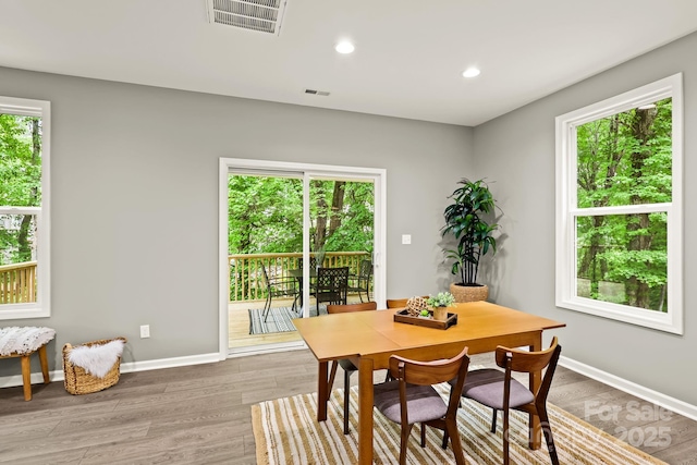 dining area featuring visible vents, baseboards, and wood finished floors