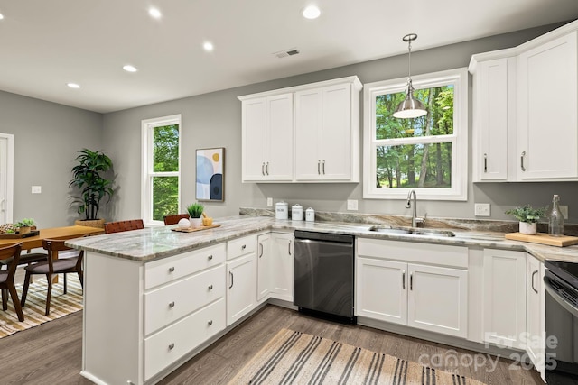 kitchen with visible vents, dishwasher, a peninsula, white cabinetry, and a sink