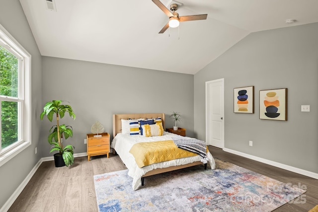 bedroom with visible vents, a ceiling fan, vaulted ceiling, wood finished floors, and baseboards