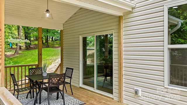 exterior space with outdoor dining area and a lawn