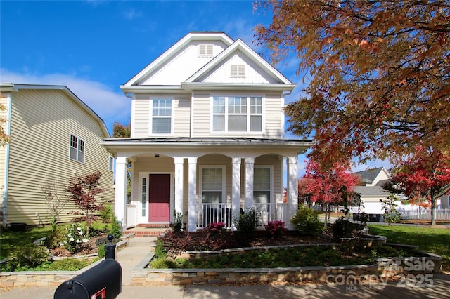 view of front facade with a standing seam roof, metal roof, and covered porch