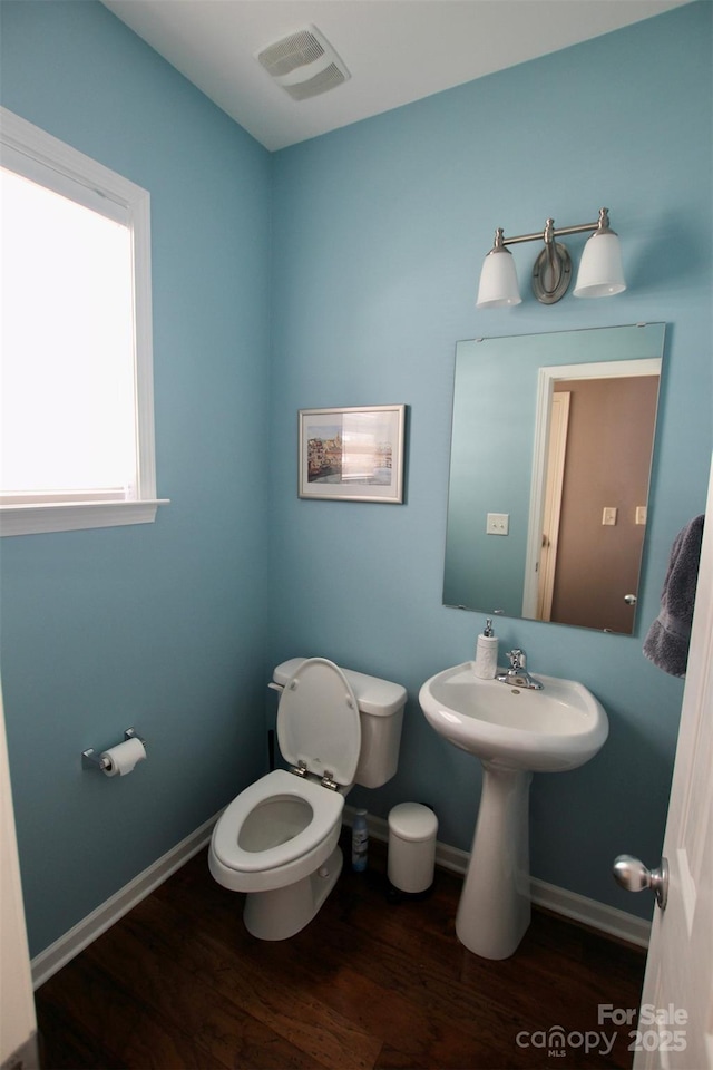 bathroom featuring baseboards, visible vents, toilet, and wood finished floors