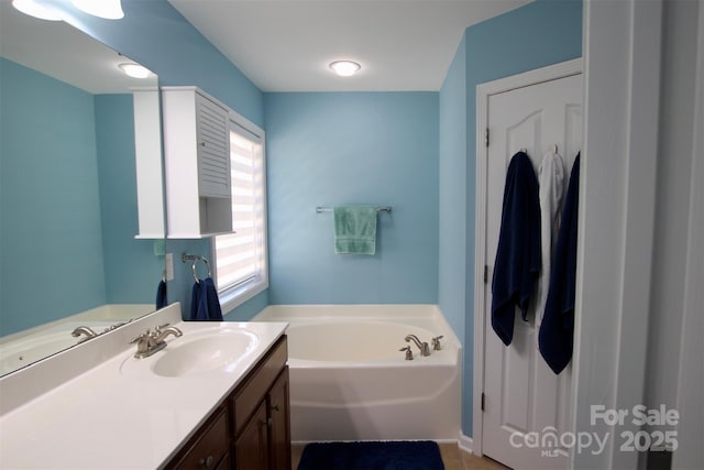 full bath featuring a garden tub and vanity