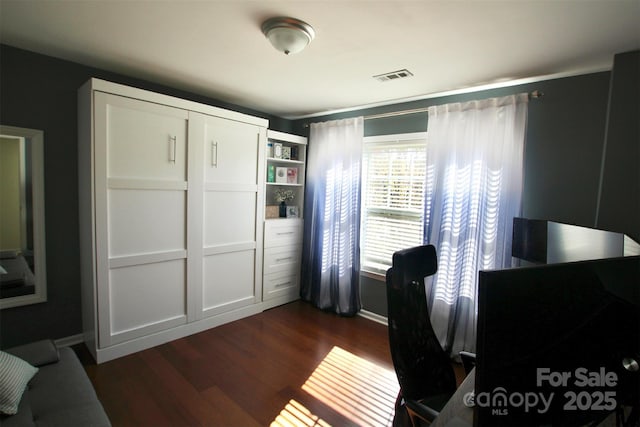 home office with dark wood-style flooring, visible vents, and baseboards