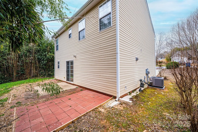 view of side of home featuring a patio and central AC