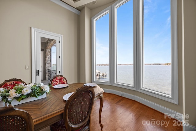 dining space featuring a water view and wood finished floors