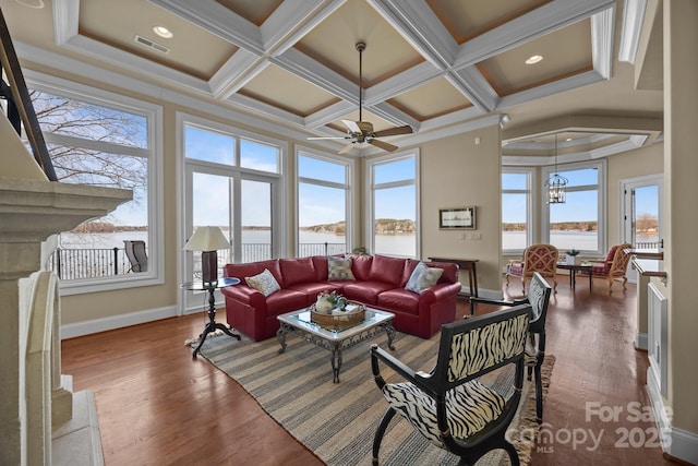 living area with visible vents, coffered ceiling, wood finished floors, and ornamental molding