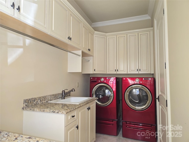 laundry room with ornamental molding, washing machine and dryer, a sink, and cabinet space