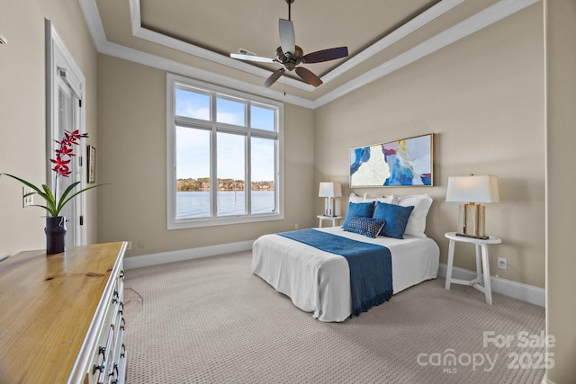 carpeted bedroom with a ceiling fan, a raised ceiling, a water view, and baseboards