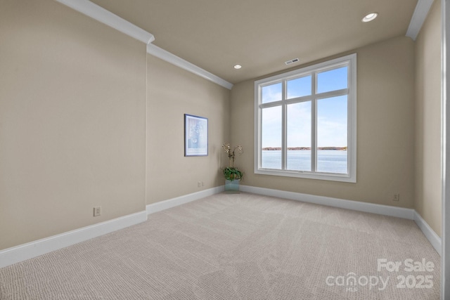 spare room featuring baseboards, visible vents, and light colored carpet