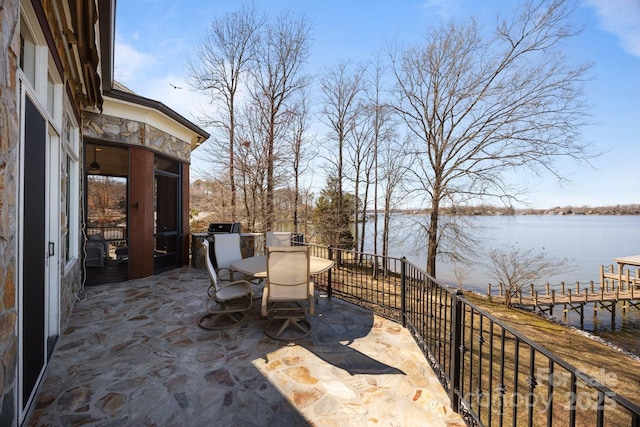 view of patio with a water view and outdoor dining area