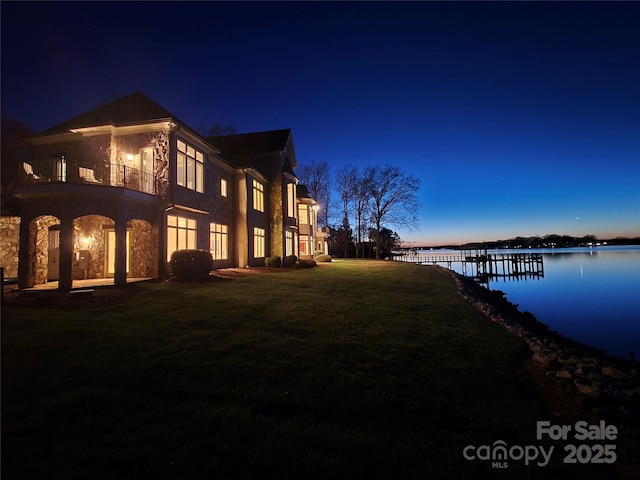 exterior space with a water view, a yard, and a balcony