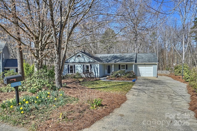 ranch-style home featuring aphalt driveway and an attached garage